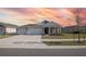 Two-story house with two-car garage, landscaped yard, and sunset in background at 2937 Hooded Crane Cv, Harmony, FL 34773