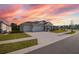 Two-story house with a two-car garage, driveway, and beautiful sunset at 2937 Hooded Crane Cv, Harmony, FL 34773