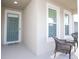 Inviting front porch with seating area and teal door at 2937 Hooded Crane Cv, Harmony, FL 34773