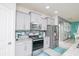 Kitchen features gray cabinets, granite counters and tile backsplash at 2937 Hooded Crane Cv, Harmony, FL 34773