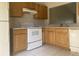 Kitchen with light oak cabinets, white appliances, and tiled floors at 34 Pine Island Cir, Kissimmee, FL 34743
