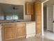 Bright kitchen features wood cabinets, dishwasher, and view into living area at 34 Pine Island Cir, Kissimmee, FL 34743