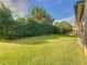 Landscaped backyard with a large grassy area at 509 Millifiora Ln, Kissimmee, FL 34759