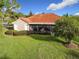 Back exterior of home showcasing a covered patio and lush green lawn at 542 Viterra Ct, Kissimmee, FL 34759