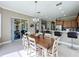 Bright dining room with a farmhouse table and chandelier, adjacent to the kitchen at 542 Viterra Ct, Kissimmee, FL 34759