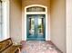 Front entry with double doors, brick flooring, and wooden bench at 542 Viterra Ct, Kissimmee, FL 34759