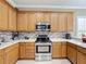Modern kitchen with stainless steel appliances and light oak cabinetry at 542 Viterra Ct, Kissimmee, FL 34759
