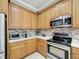 Modern kitchen with stainless steel appliances and light oak cabinetry at 542 Viterra Ct, Kissimmee, FL 34759