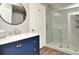 Modern bathroom with blue vanity, large mirror, and glass shower at 720 Siena Palm Dr # 202, Celebration, FL 34747