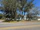 Street view of teal house with trees and a road at 3407 Avenue J Nw, Winter Haven, FL 33881