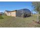 Home exterior showcasing a screened patio and yard at 5043 Vantage Ct, St Cloud, FL 34772