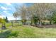 Landscaped backyard with stone seating area, mature trees, and lake view at 521 Milano Rd, Kissimmee, FL 34759