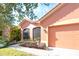 Orange stucco home with two car garage and well manicured landscaping at 521 Milano Rd, Kissimmee, FL 34759