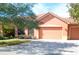 Attractive orange home with two-car garage, landscaping and paver driveway at 521 Milano Rd, Kissimmee, FL 34759
