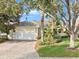 House exterior featuring a tile roof, white garage door, and lush landscaping at 12021 Jewel Fish Ln, Orlando, FL 32827