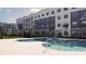 Community pool with tiled deck and building view at 1230 Southstation Pl Pl # 114, Orlando, FL 32809