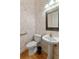 Small bathroom with pedestal sink and patterned wallpaper at 1280 Osprey Landing Dr, Lakeland, FL 33813