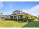 Back of house with screened lanai, lush landscaping, and a large yard at 1280 Osprey Landing Dr, Lakeland, FL 33813