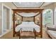 Bedroom with a four-poster bed and sitting area at 1501 Sunset Pointe Pl, Kissimmee, FL 34744