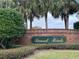Brick entrance sign of Sunset Pointe community with lush landscaping at 1501 Sunset Pointe Pl, Kissimmee, FL 34744
