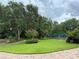 Tennis court in a lush, well-maintained community with mature trees and landscaping at 1501 Sunset Pointe Pl, Kissimmee, FL 34744