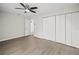 Bright bedroom with ceiling fan, wood-look floors, and ample closet space at 1621 Ne 2Nd St # 203, Ocala, FL 34470