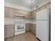 Bright kitchen features white appliances and taupe cabinets at 1621 Ne 2Nd St # 203, Ocala, FL 34470
