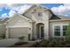 One-story home with light beige exterior, two-car garage, and landscaping at 3306 Sagebrush St, Harmony, FL 34773