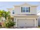 Two-story house with light beige siding, a two-car garage, and landscaping at 3112 Armstrong Spring Dr, Kissimmee, FL 34744