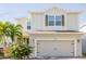 Two-story house with light beige siding, a two-car garage, and landscaping at 3112 Armstrong Spring Dr, Kissimmee, FL 34744