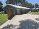 House exterior with a gray metal roof, double doors, and a fenced yard at 4040 Ne 95Th Rd, Wildwood, FL 34785