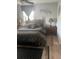 Large bedroom with king-size bed, wood floors, and window coverings at 4040 Ne 95Th Rd, Wildwood, FL 34785