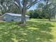 Gray house with large lawn and mature trees at 4040 Ne 95Th Rd, Wildwood, FL 34785
