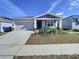 One-story house with gray roof, attached garage, and front porch at 590 Tanaro Ln, Haines City, FL 33844