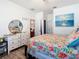 Bedroom with floral bedding, dresser, and view into living room at 590 Tanaro Ln, Haines City, FL 33844