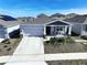One-story house with gray roof, attached garage, and driveway at 590 Tanaro Ln, Haines City, FL 33844
