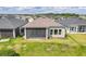 Single-story house with a screened patio, situated in a neighborhood with other homes at 128 Mosaic Blvd, Daytona Beach, FL 32124