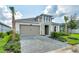 One-story house with a gray and beige exterior, paved driveway, and tropical landscaping at 128 Mosaic Blvd, Daytona Beach, FL 32124