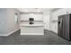 Modern kitchen with white cabinets, island, and stainless steel appliances at 3327 Chinotto Dr, Lake Alfred, FL 33850