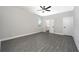 Spacious bedroom with ceiling fan and grey vinyl plank flooring at 3327 Chinotto Dr, Lake Alfred, FL 33850