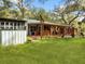 Spacious backyard with a large covered patio, lush lawn, and a detached workshop at 10820 Sw 31St Way, Webster, FL 33597