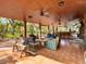 Relaxing covered patio with comfortable seating, a bar area, and a large TV at 10820 Sw 31St Way, Webster, FL 33597