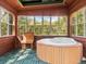 Relaxing hot tub in a sunlit, enclosed area with wooden walls and flooring at 10820 Sw 31St Way, Webster, FL 33597