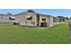 Mobile home backyard with grassy lawn and partial view of home at 1610 Reynolds Rd # 5, Lakeland, FL 33801