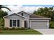 New home exterior features a two-car garage and attractive landscaping at 1153 Deepwater Cir, Eagle Lake, FL 33839