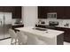 Modern kitchen boasts dark cabinetry, an island, and stainless steel appliances at 1153 Deepwater Cir, Eagle Lake, FL 33839
