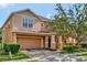 Two-story house with orange siding, a two-car garage, and lush landscaping at 625 Legacy Park Dr, Casselberry, FL 32707