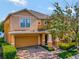 Two-story house with orange siding, a two-car garage, and lush landscaping at 625 Legacy Park Dr, Casselberry, FL 32707