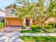 Two-story house with orange siding, a two-car garage, and a large tree in front at 625 Legacy Park Dr, Casselberry, FL 32707