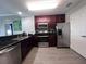 Modern kitchen with dark wood cabinets, stainless steel appliances, and granite countertops at 14501 Grove Resort Ave # 1617, Winter Garden, FL 34787